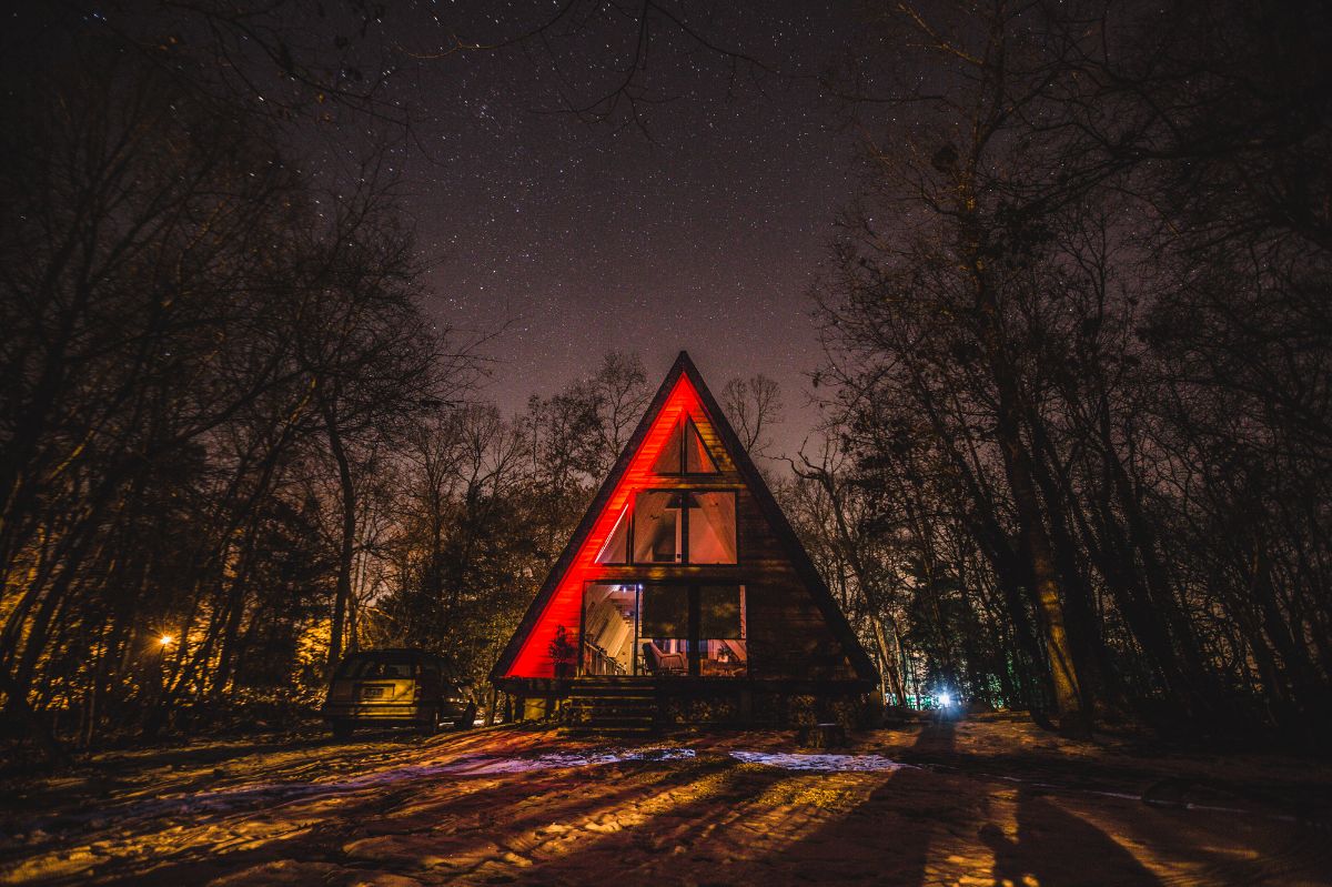 Lokal Aframe Cabin at night with stars and red LED lighting up half of the aframe