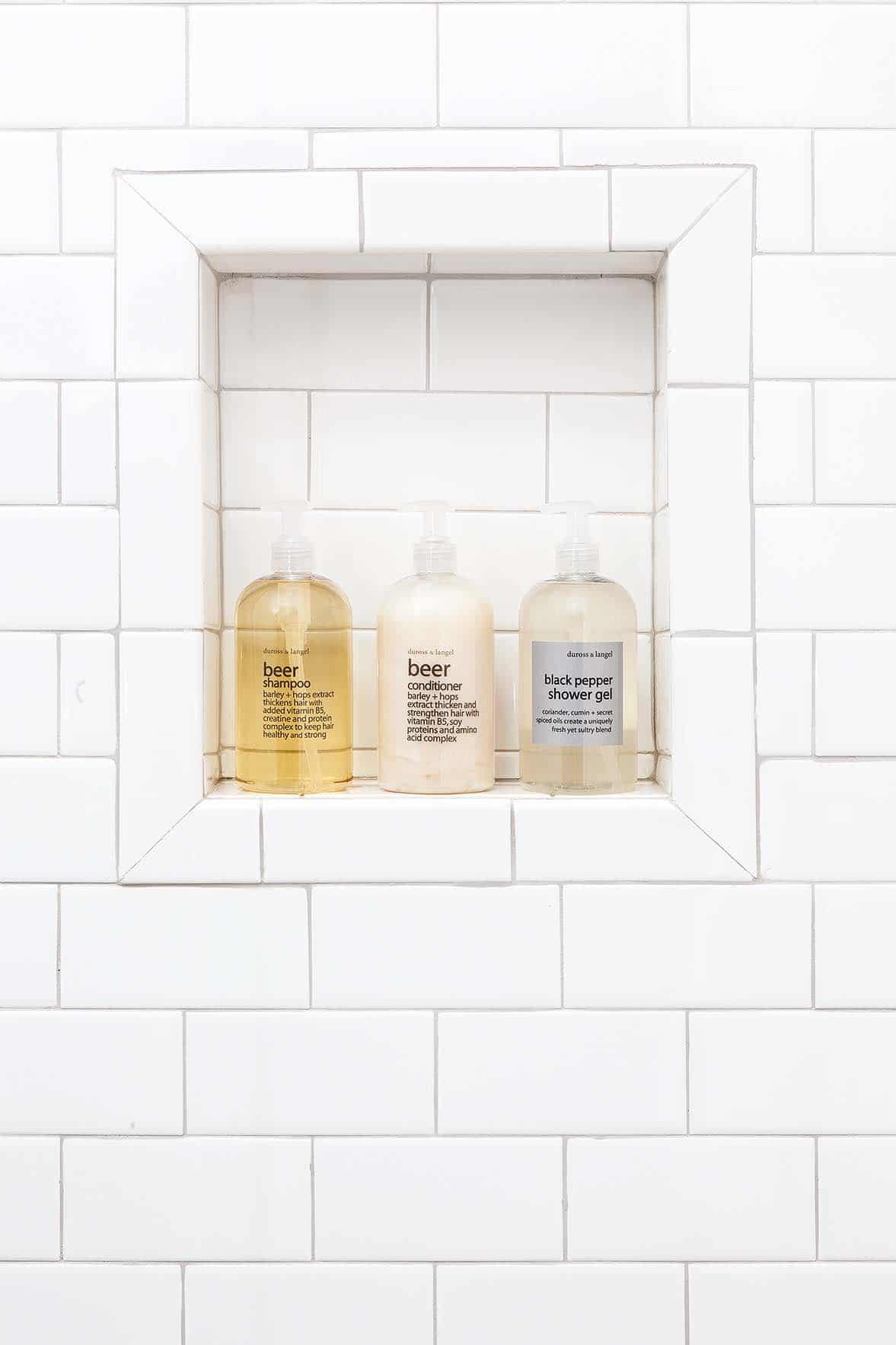 A shower niche with three bottles of body wash products.