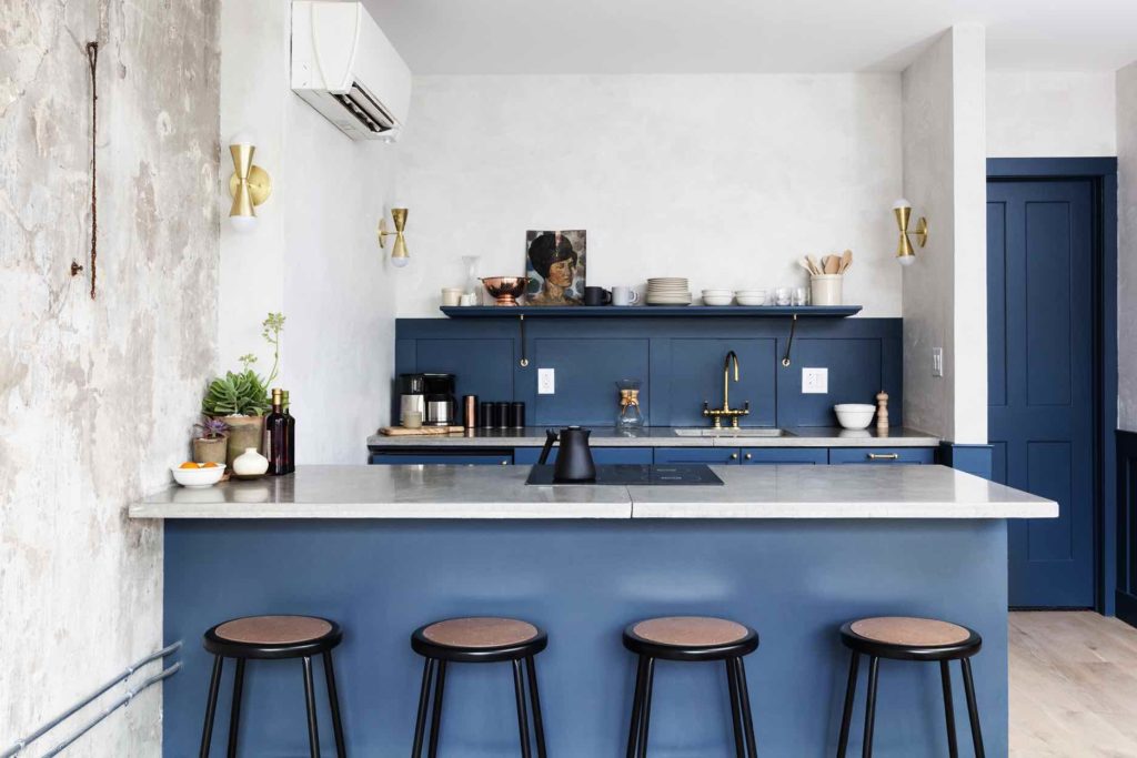 Bright Blue kitchen in the Will suite at Lokal Hotel Old City with four stools brass hardware and an exposed shelf