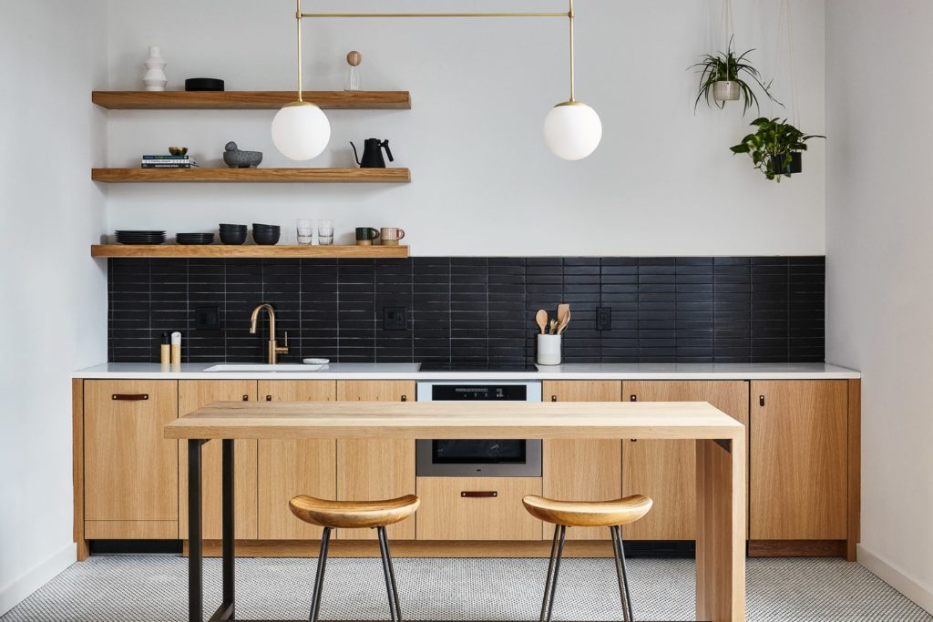 Efficiency apartment style kitchen in lokal hotel fishtown with sleek scandinavian color scheme of white, black and white oak and black steel