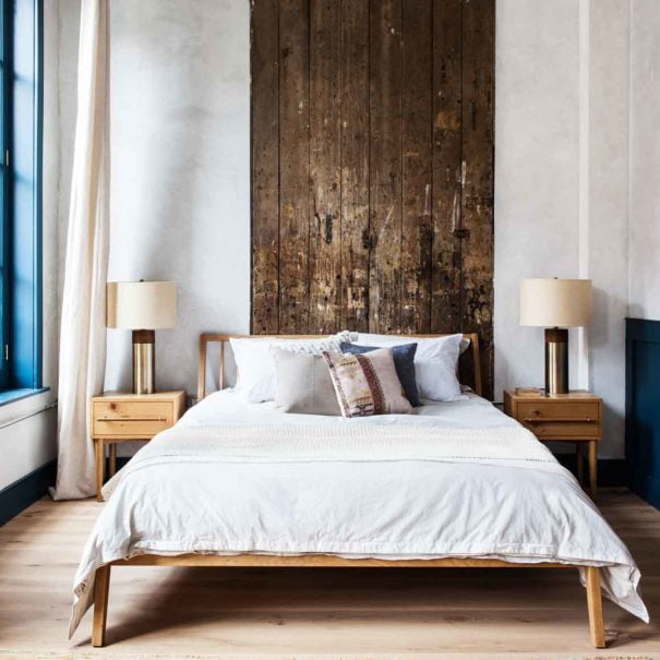 Queen bed with side tables, floor to ceiling windows and reclaimed wood headboard