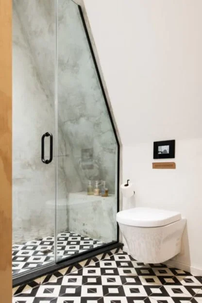 A modern bathroom with a glass-enclosed shower and a white toilet.