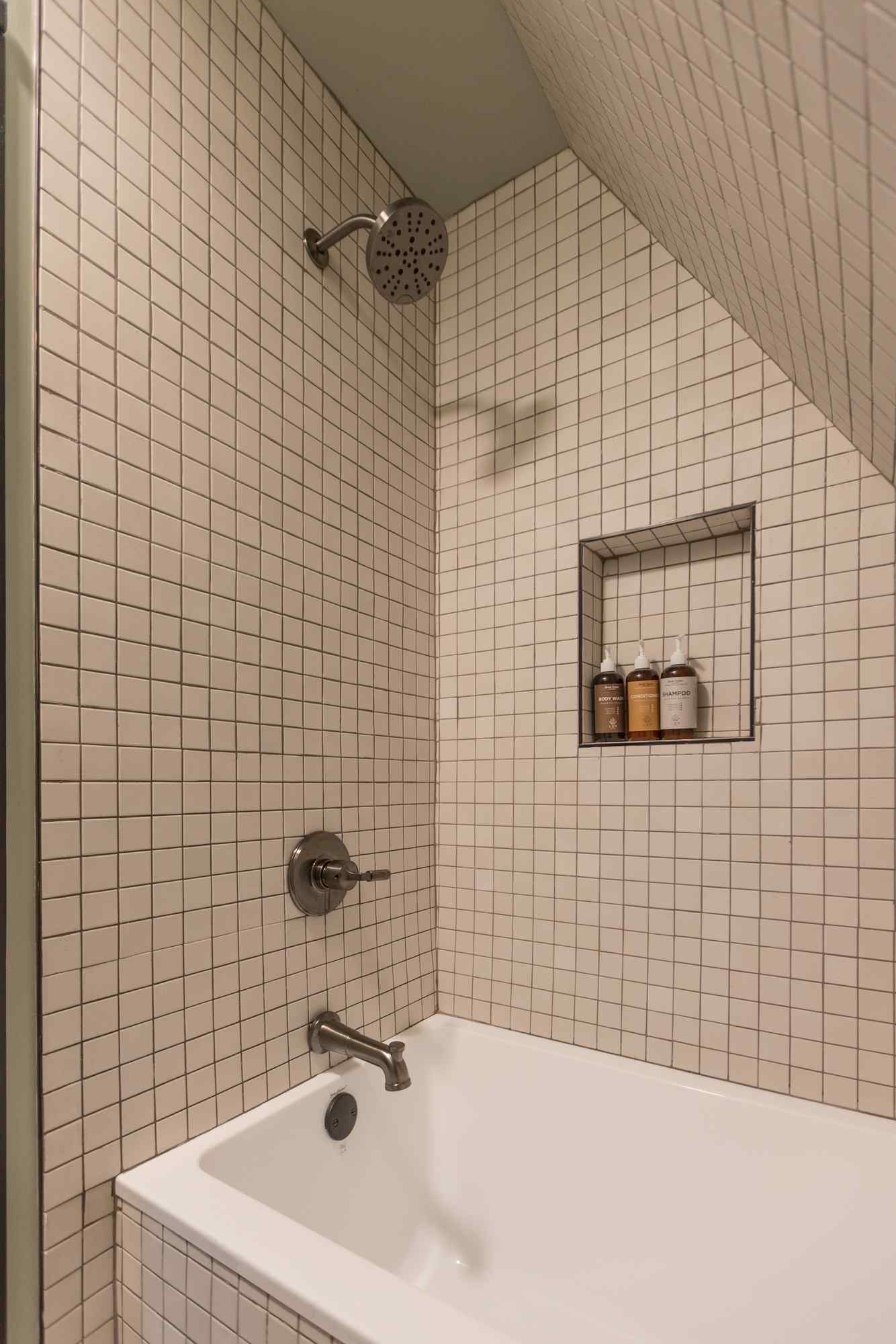 A bathroom with a white tub and shower with a rainfall showerhead